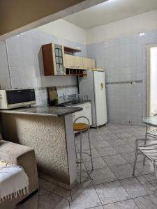 巴拉奈里奥-坎布里乌Casa de família e Quarto的厨房配有柜台和冰箱。