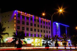 安曼Qaser Al-Sultan Hotel Suites的建筑的侧面有紫色的灯