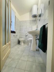 GuigliaCasa del Viandante Borgo dei Sassi di Roccamalatina的白色的浴室设有水槽和卫生间。