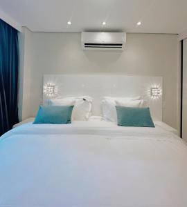 圣保罗Moema Times Square SP - Luxury Suíte的卧室配有带蓝色枕头的大型白色床