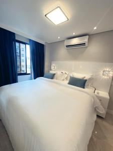 圣保罗Moema Times Square SP - Luxury Suíte的卧室设有一张白色大床和一扇窗户。