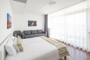 布达佩斯Rooftop City Residence的一间卧室配有一张大床和一张沙发