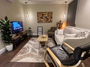 利雅德Cozy apartment, two bedroom, full kitchen的带沙发和电视的客厅