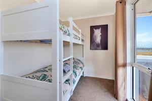 沃纳姆堡高地景家庭小屋的一间卧室设有双层床和窗户。