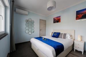 埃斯托利尔Gold Coast Photography Inn的一间卧室配有一张带蓝白色床单的大床