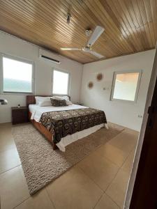 阿克拉Emron Homelodge的一间卧室设有一张带木制天花板的大床