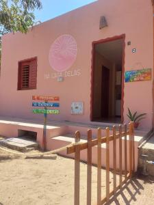 杰里科科拉Na Casa Delas Jeri - com Churrasqueira的粉红色的建筑,前面有栅栏