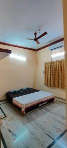 JagdalpurSangeeta's Homestay的配有吊扇的客房内的一张床位