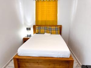 圣胡安OMERO Ocean Park的一间小卧室,配有一张带黄色窗户的床