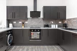 彼得伯勒Cowgate Luxury Apartments的厨房配有黑色橱柜和洗碗机。