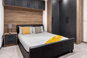 彼得伯勒Cowgate Luxury Apartments的一间卧室配有一张大床和黑色床头板