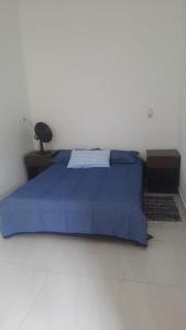 莫埃达Sítio Alazão的一间卧室配有一张蓝色的床和一张桌子上的台灯