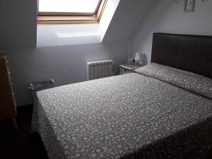 里贝拉Atico vistas mar的一间卧室设有一张床和一个窗口