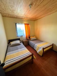洛斯安赫莱斯Cabañas Alto las Torres的小型客房 - 带2张床和窗户