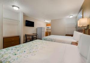 奥兰多HomeTowne Studios by Red Roof Orlando - UCF Area的酒店客房设有两张床和电视。