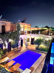 马拉喀什Riad Rime Garden Marrakech的一座大房子,前面设有一个游泳池