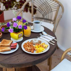 马萨特兰Hill House Mazatlan - Bed & Breakfast的一张桌子,早餐包括鸡蛋和烤面包