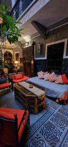 马拉喀什Riad des Mile Nuits的客房设有两张床、一张桌子和一张沙发。