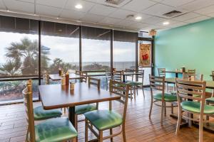 代托纳海滩热带风度假酒店的餐厅设有桌椅和大窗户。