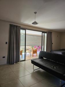 迈普Alquiler Maipú Mendoza的带沙发的客厅和天井美景