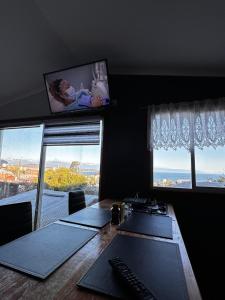 蒙特港Hostal y Cabañas Mirando al Mar的办公室,带桌子,有两个窗口和显示器