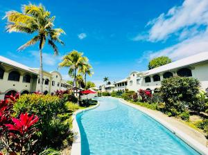 棕榈湾Appartment in Palm Cove的棕榈树和别墅的度假游泳池