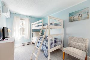 奥克布拉夫斯Island Breeze的卧室配有白色双层床和椅子