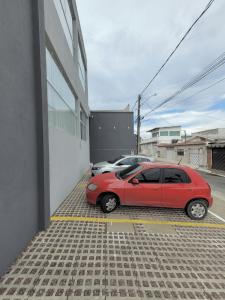 马瑙斯Hotel Manaus - Dom Pedro I的停在大楼旁边的停车场的红色汽车