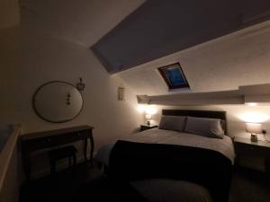 彭布罗克Cosy Moat House Cottage #6的一间卧室配有一张带两盏灯和镜子的床