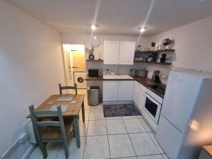 彭布罗克Cosy Moat House Cottage #6的厨房配有桌子和白色冰箱。