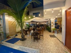曼克拉Hospedaje Ola Marina的一间设有桌椅和棕榈树的餐厅