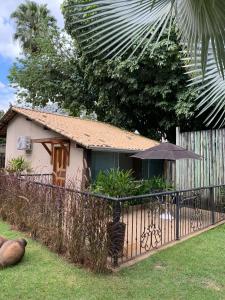 佩尼多Pousada Reserva Penedo的一座带围栏和雨伞的小房子