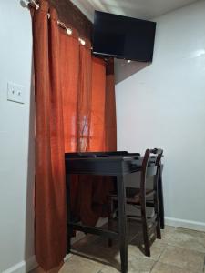 红木城Garden motel的一张桌子,电视机在带窗帘的房间