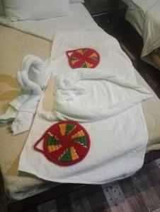 阿斯旺NeNeKaTo Nubian House的床上的两条白色毛巾,红色和绿色