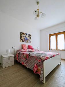 阿巴迪亚圣萨尔瓦托雷I Due Ciliegi的白色卧室配有带粉红色枕头的床