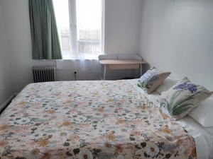 汉密尔顿Nesting In Hamilton East的一间卧室配有一张带花卉被子的床