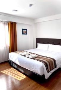 乌鲁班巴Hotel Andes de Urubamba的一间卧室配有一张带白色床单的大床