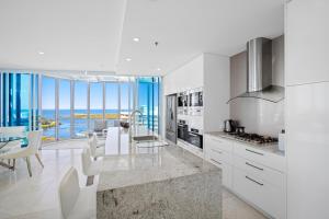 黄金海岸Reflections Tower Two的一间厨房、白色橱柜和一间享有美景的用餐室