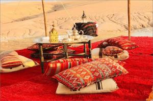 马拉喀什The magic of camping的沙漠里的一组枕头和一张桌子
