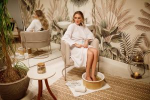 布卢梅瑙Villa do Vale Boutique Hotel的坐在浴室椅子上的女人