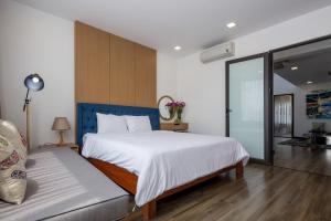 岘港Luxury Beach Villa Da Nang的卧室配有一张白色的大床和一张沙发。