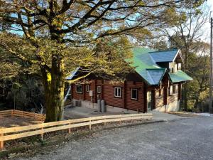 佐贺市Rental Cottage Forest Breathing - Vacation STAY 13733的大型小木屋,设有绿色屋顶