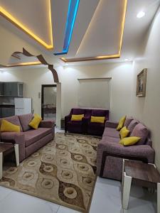 塔伊夫شاليهات ستي لاند的客厅配有紫色沙发和黄色枕头