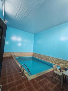 塔伊夫شاليهات ستي لاند的蓝色墙壁的房间内的游泳池