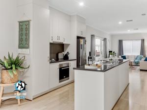 维克多港3BR Contemporary Home with Sea Views的厨房配有白色橱柜和台面