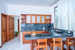 阿约拉港EXCLUSIVE CONDO GALAPAGOS & BEYOND 2的厨房配有木制橱柜和带椅子的柜台。