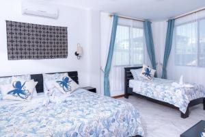 阿约拉港EXCLUSIVE CONDO GALAPAGOS & BEYOND 2的一间卧室设有两张床和蓝色窗帘