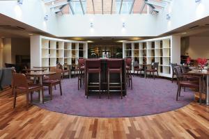 沃尔索尔伯明翰沃尔萨尔丽笙公园酒店的图书馆内带桌椅的用餐区