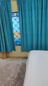 塔伊夫شاليهات ستي لاند的一间卧室配有蓝色窗帘和窗户