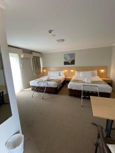 梅特兰梅特兰城市汽车旅馆的酒店客房设有两张床和一张桌子。